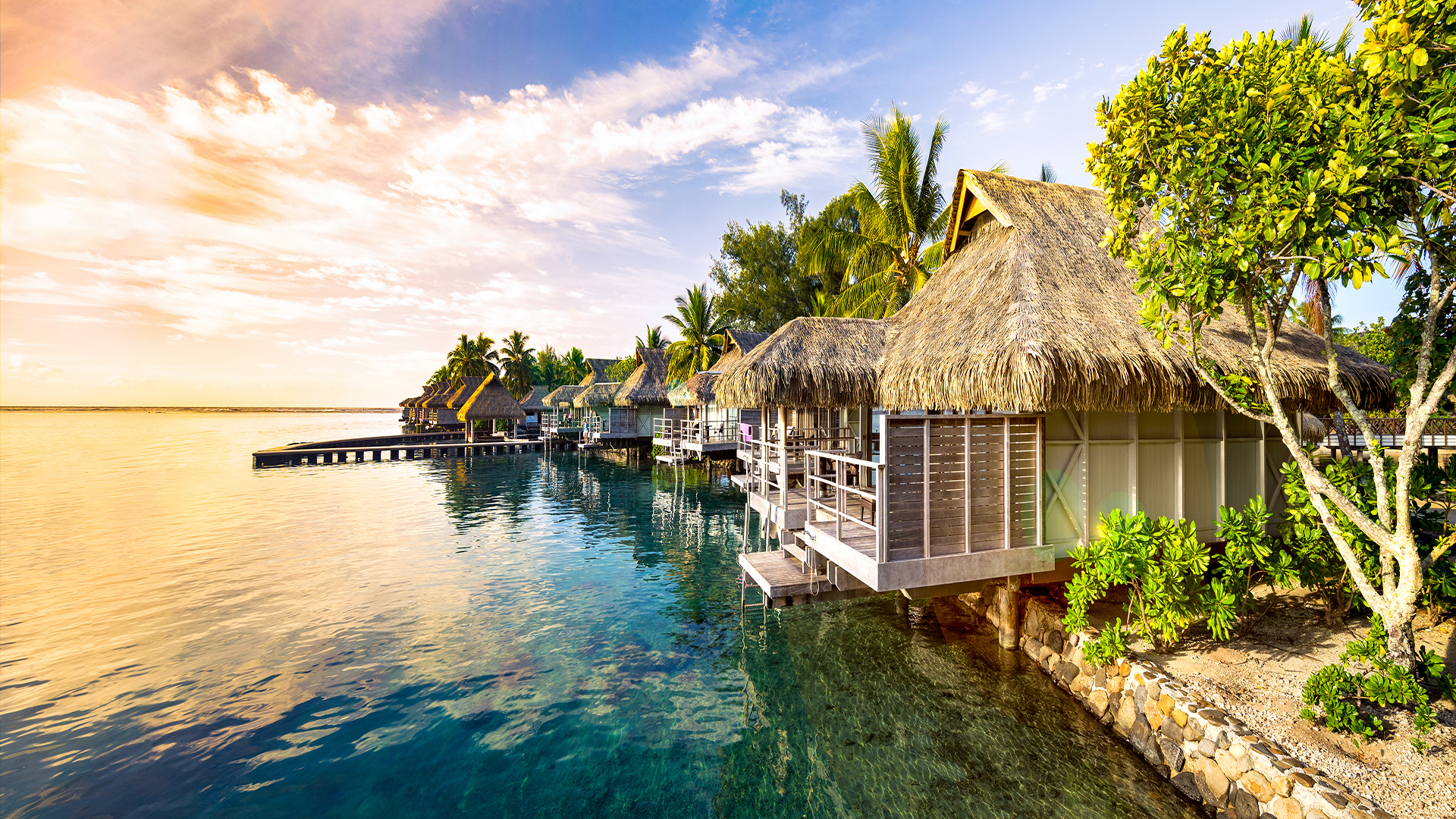 Altmodische bungalows direkt am klaren, blauen Wasser